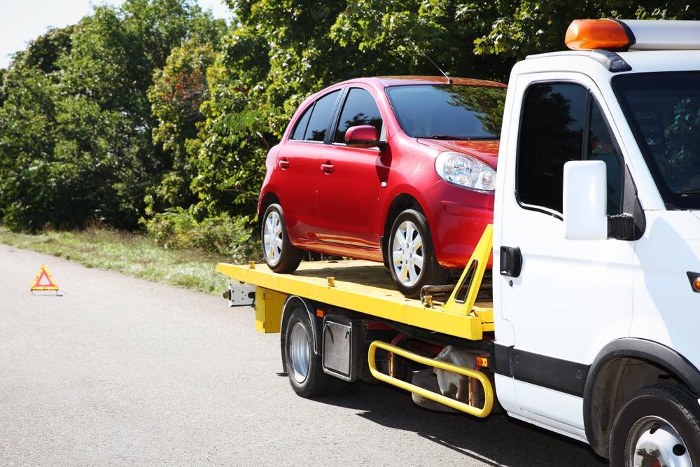 Red car loaded on a flatbed tow truck